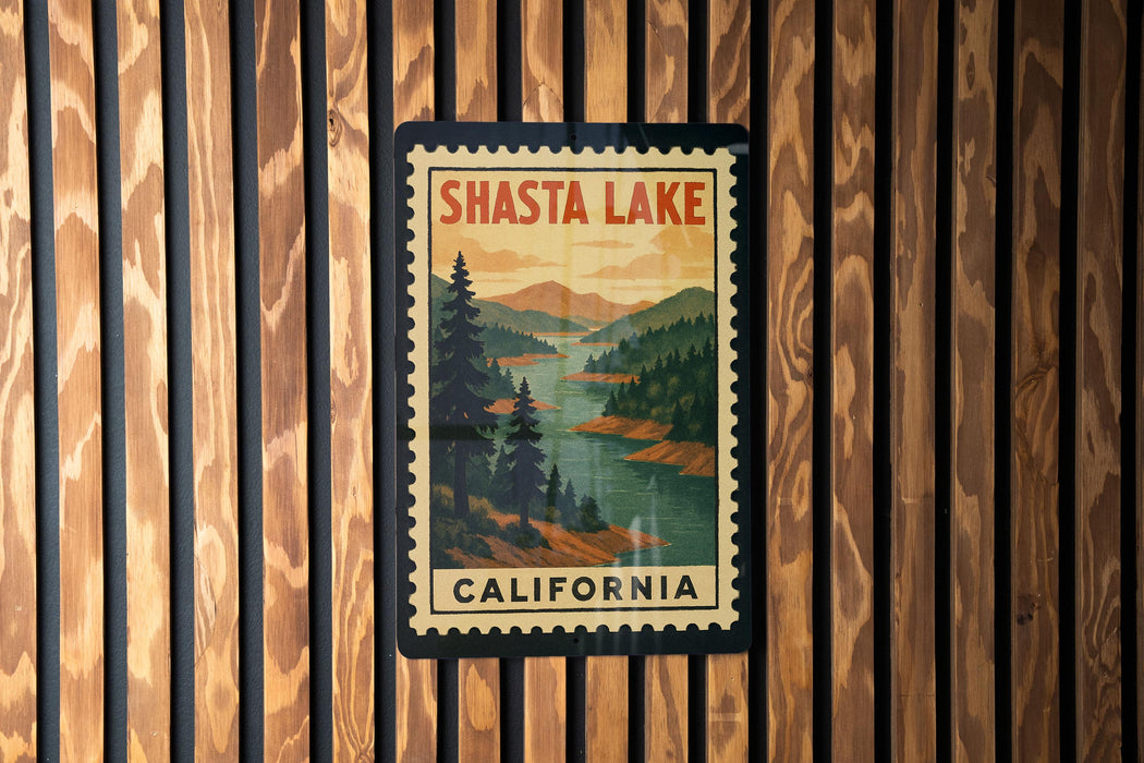 A vintage-style postage stamp depicting Shasta Lake, with the text "SHasta Lake" and "California" printed on it, is displayed on a wooden wall.