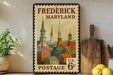 A vintage-style postage stamp from Frederick, Maryland, featuring a colorful illustration of the city's architecture and landmarks.