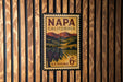 A vintage Napa California postage stamp is displayed on a wooden wall.