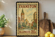 A framed vintage-style stamp depicting a cityscape of Evanston, Illinois, with a clock tower and buildings, is displayed on a shelf next to a wooden cutting board and a potted plant.