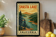 A framed vintage-style poster of Shasta Lake, California, featuring a scenic landscape with mountains, pine trees, and a river.