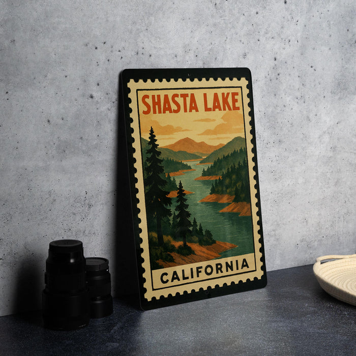 A framed vintage-style poster of Shasta Lake, California, featuring a scenic landscape with pine trees and a river.