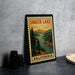 A framed vintage-style poster of Shasta Lake, California, featuring a scenic landscape with pine trees and a river.