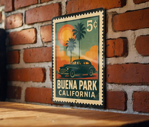 A vintage postage stamp featuring a car and palm trees, with the text "BUENA PARK CALIFORNIA" printed on it.