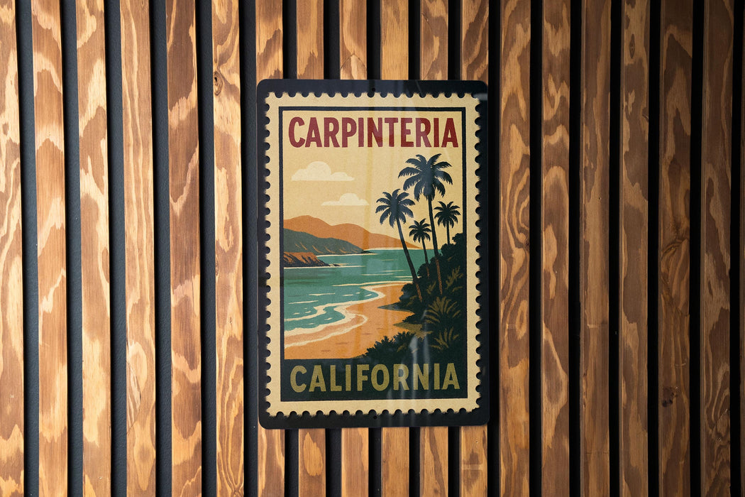 A vintage-style poster of Carpinteria, California, featuring palm trees and a beach landscape, is displayed on a wooden wall.