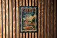 A vintage postage stamp from Carmel, Indiana, featuring a building with a clock tower.
