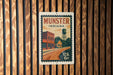 A vintage-style postage stamp from Munster, Indiana, featuring a building and a water tower, is displayed on a wooden wall.