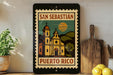 A framed poster of a church with a tropical landscape in the background, displayed on a shelf next to a wooden cutting board and some lemons.