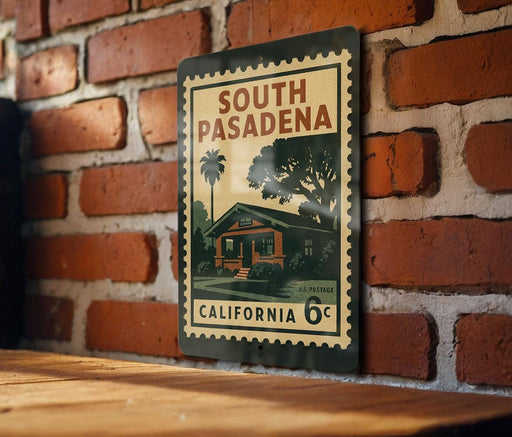 A vintage-style metal sign with the text "SOUTH PASADENA" and "CALIFORNIA 6¢" displayed on a brick wall.