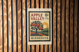 A vintage-style postage stamp from Minnesota, featuring an illustration of an apple tree with apples, mounted on a wooden wall.