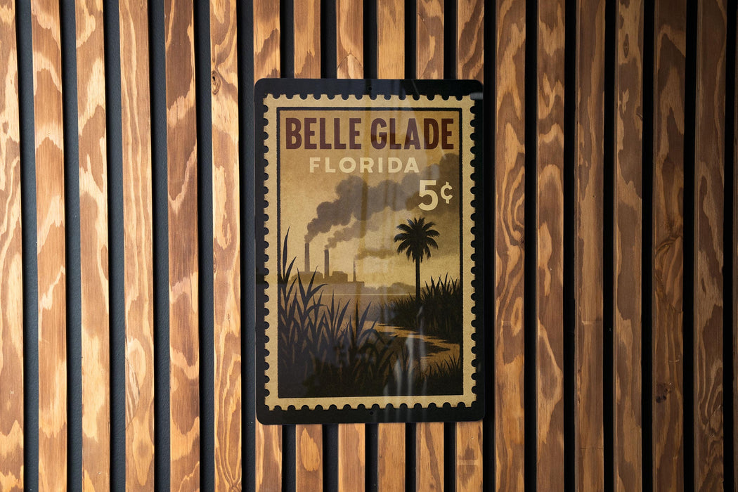 A vintage postage stamp from Belle Glade, Florida, featuring a palm tree and a steam-powered train in the background.