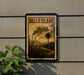 A vintage-style postage stamp from Belle Glade, Florida, featuring a palm tree and steam rising from a factory, mounted on a wall.