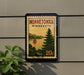 A Minnesota postage stamp featuring a scenic landscape with a sailboat on a lake, mounted on a wall next to a plant.