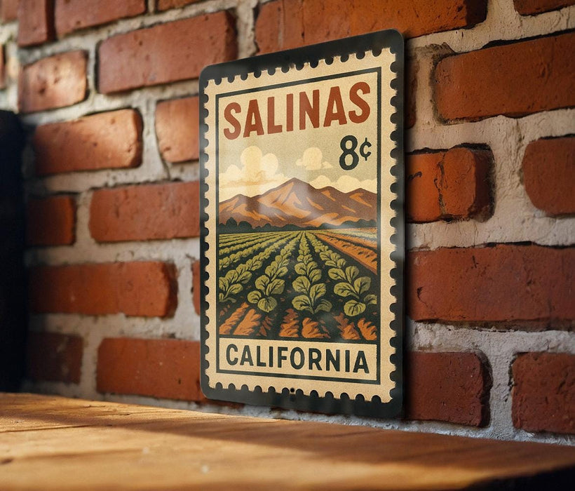 A metal sign with a vintage-style illustration of a farm and mountains, mounted on a brick wall.