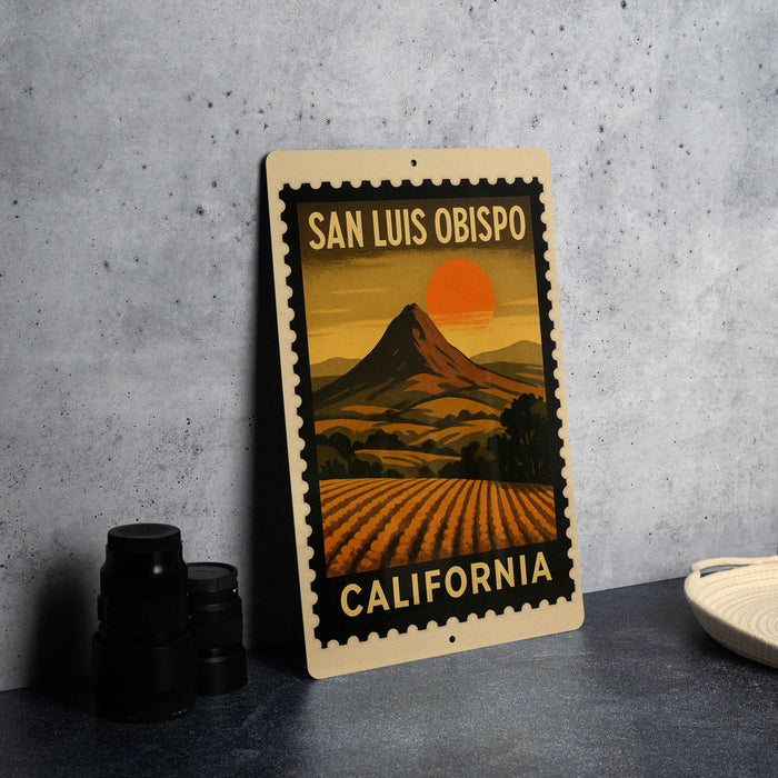 A framed vintage-style poster of San Luis Obispo, California, featuring a mountain landscape with a sunset.