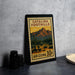 A metal sign with a desert landscape and mountains, featuring the text "Catalina Foothills Arizona 10¢" on it.