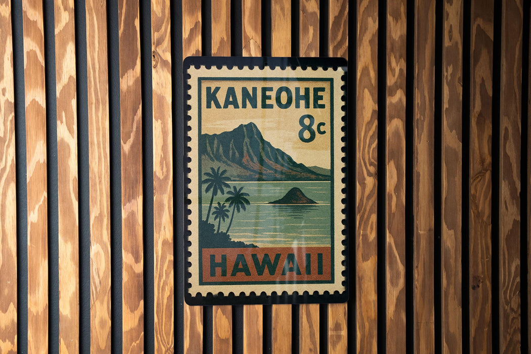 A vintage-style postage stamp from Hawaii, featuring a mountain landscape and palm trees, is displayed on a wooden wall.