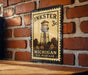 A vintage-style metal stamp depicting a water tower, mounted on a brick wall.