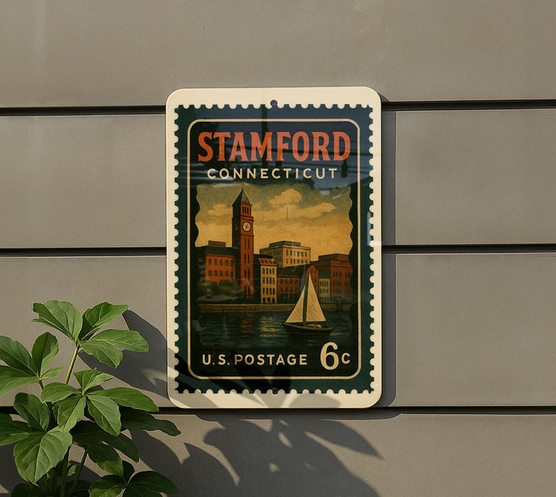 A vintage postage stamp from the United States, featuring a cityscape and a sailboat, is displayed on a wall.