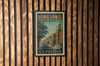 A vintage postage stamp from New Jersey, featuring a street scene with a clock tower, is displayed on a wooden wall.