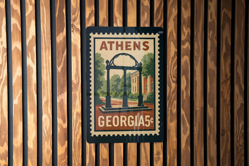 A vintage-style postage stamp from Georgia featuring a building and trees, mounted on a wooden wall.
