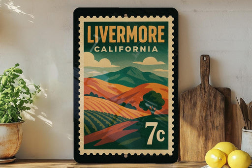 A vintage-style poster of Livermore, California, featuring a landscape with rolling hills and mountains, is displayed on a wall next to a wooden cutting board and a potted plant.