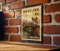 A metal stamp with a vintage-style illustration of a bridge, mounted on a brick wall.