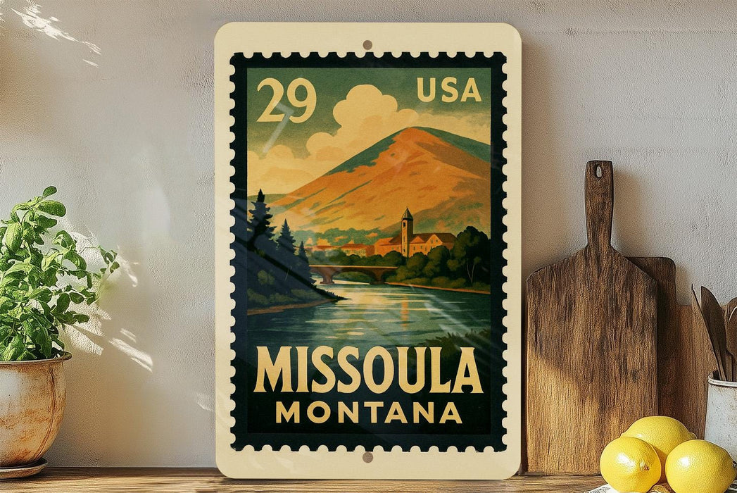 A vintage-style metal stamp depicting a scenic landscape of Missoula, Montana, with a mountain, river, and town in the background.