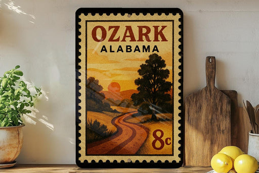 A framed poster of a scenic landscape with a winding road and a sunset in the background, displayed on a wall next to a wooden cutting board and some potted plants.