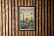 A vintage-style postage stamp from Indiana featuring a cityscape and a steam chimney, mounted on a wooden wall.
