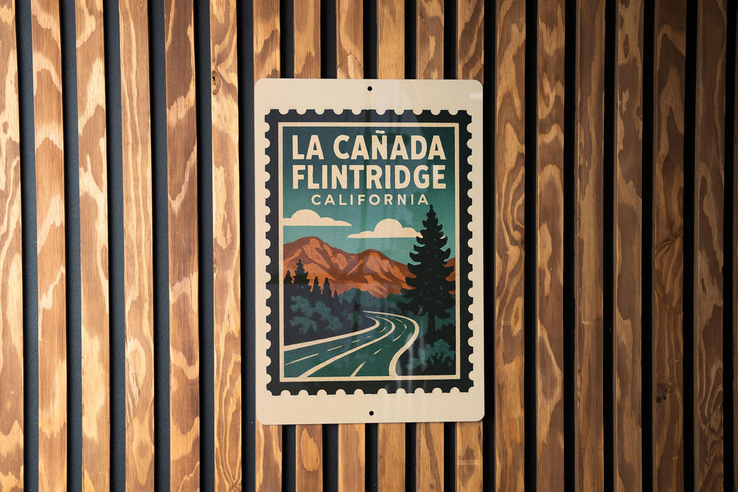 A sign for La Canada Flintridge, California, featuring a scenic mountain landscape with a winding road.