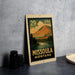 A metal sign with a mountain landscape and a river, featuring the text "29 USA" and "MISSOULA MONTANA".