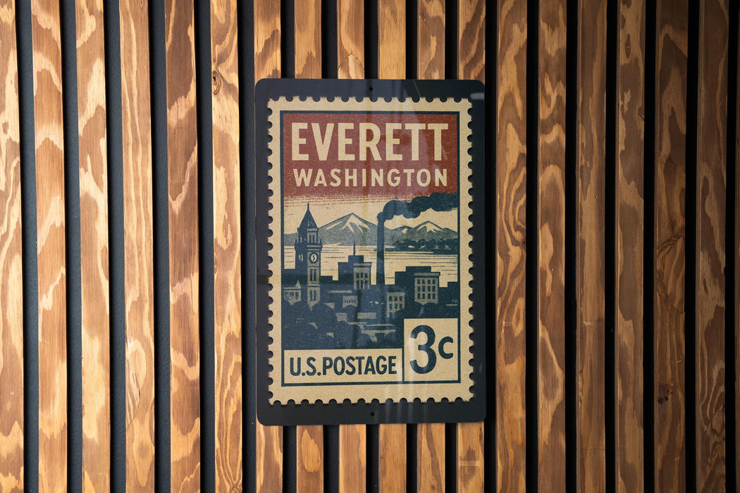 A vintage-style postage stamp from Everett, Washington, mounted on a wooden wall.