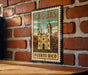 A vintage-style metal sign with a graphic of a church and palm trees, mounted on a brick wall.