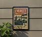 A vintage-style postage stamp from Everett, Washington, featuring a cityscape and mountains, mounted on a wall.