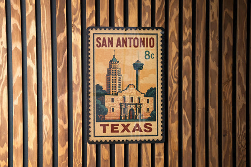 A vintage-style metal stamp or sign with the text "SAN ANTONIO 8c TEXAS" and an illustration of a building, likely representing the historic San Antonio, Texas.