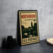 A vintage postage stamp from Illinois, featuring a scenic illustration of a town and a river, is displayed on a table.