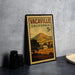 A vintage-style stamp depicting a rural landscape with a farm and mountains in the background, placed on a countertop next to some black camera lenses.