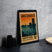 A framed vintage postage stamp from Louisiana, featuring an illustration of a city skyline at sunset.