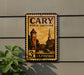 A vintage-style postage stamp from North Carolina, featuring a clock tower and church, mounted on a wall.