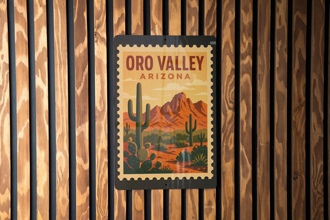 A vintage-style poster of the Oro Valley in Arizona, featuring a desert landscape with mountains and cacti, is displayed on a wooden wall.