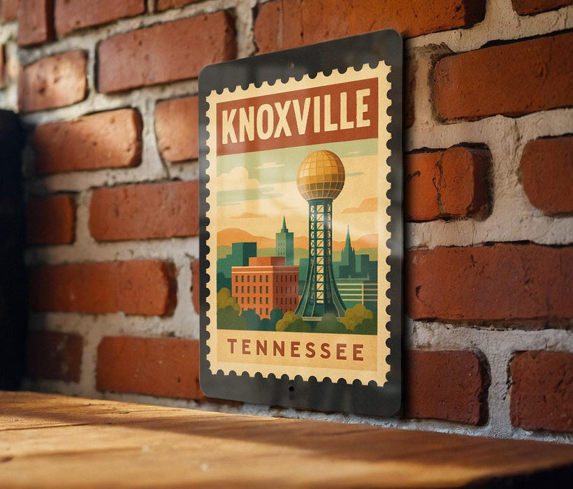 A metal sign with a vintage-style illustration of Knoxville, Tennessee, featuring the city's iconic landmark, the Space Needle, against a brick wall background.