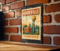 A metal sign with a vintage-style illustration of Knoxville, Tennessee, featuring the city's iconic landmark, the Space Needle, against a brick wall background.