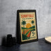 A framed vintage postage stamp from Sunnyvale, California, featuring a palm tree and a sunset landscape.