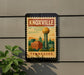 A sign depicting the Knoxville, Tennessee skyline, featuring the iconic Tennessee Water Tower, is mounted on a wall.