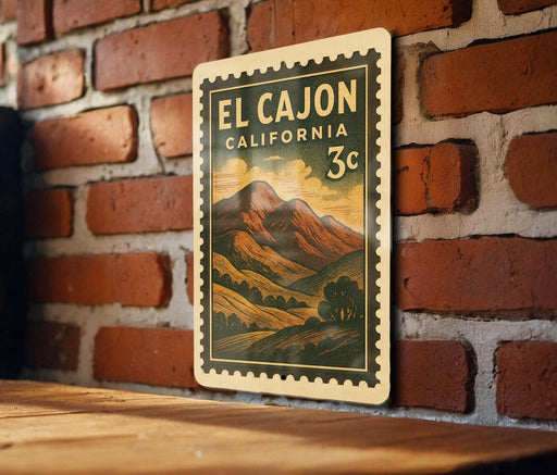 A vintage-style postage stamp from California, featuring a mountain landscape, is displayed on a brick wall.