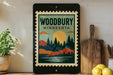 A framed poster of a scenic landscape with a sunset and pine trees, displayed on a shelf next to a wooden cutting board and a potted plant.