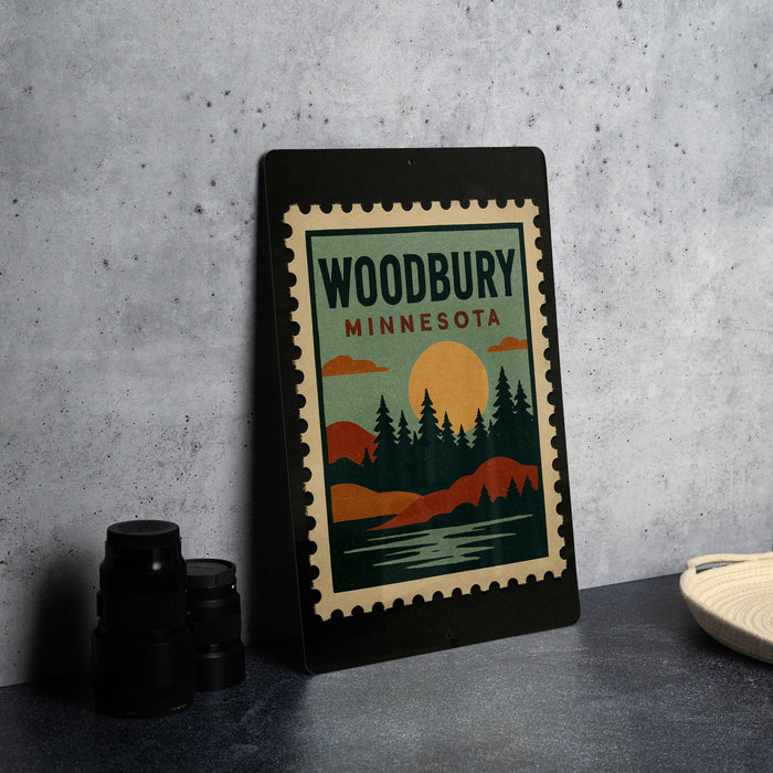 A framed poster of Woodbury Minnesota, featuring a scenic landscape with mountains, trees, and a sunset, is displayed on a wall.