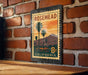 A vintage-style metal sign with a palm tree and sunset landscape, mounted on a brick wall.