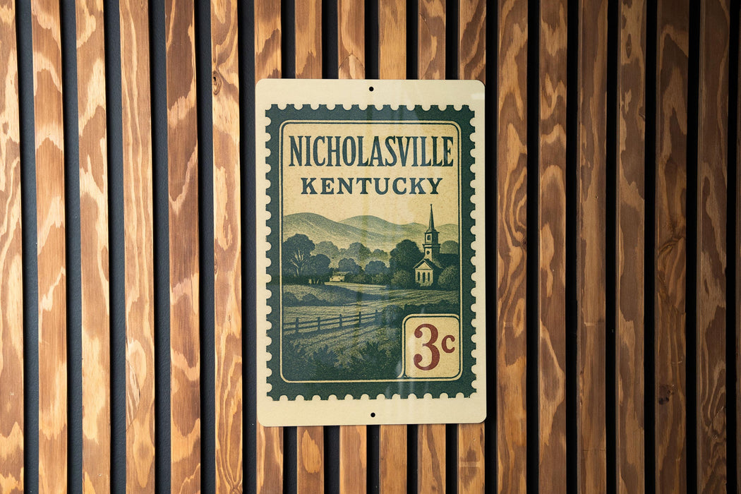 A vintage-style postage stamp from Kentucky, featuring a church and a rural landscape, is displayed on a wooden wall.